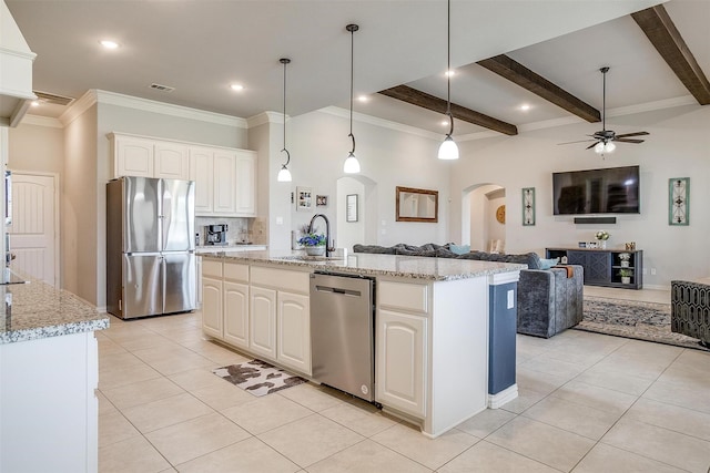 kitchen with pendant lighting, stainless steel appliances, sink, and a center island with sink