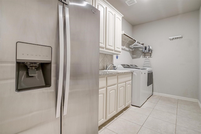 laundry room with cabinets, separate washer and dryer, sink, and light tile patterned floors