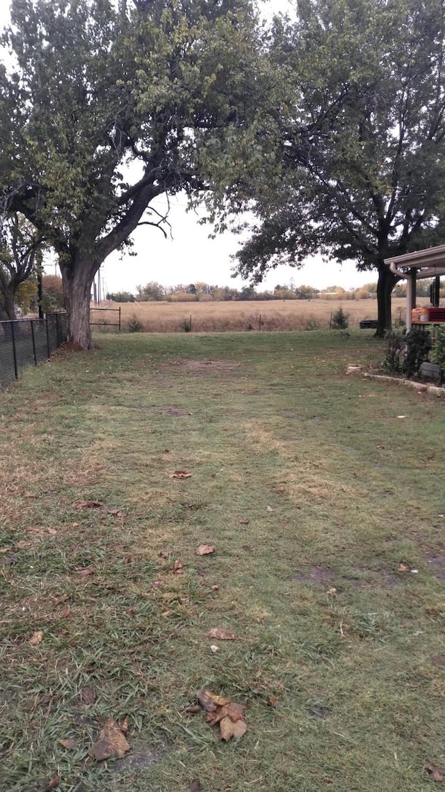 view of yard featuring a rural view and fence