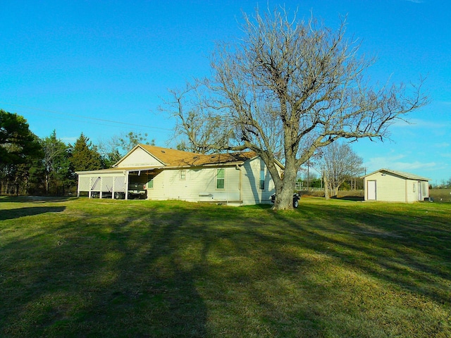 rear view of house with an outbuilding and a lawn