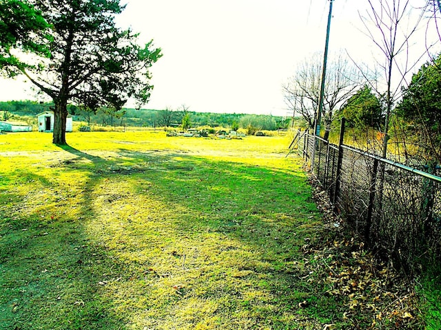 view of yard featuring a rural view and fence