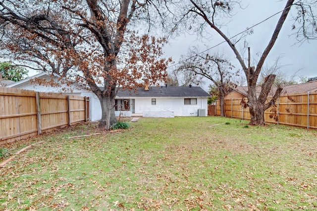 back of property featuring a yard and central AC