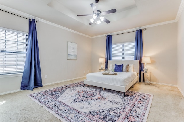 bedroom featuring light carpet, ceiling fan, a tray ceiling, and ornamental molding