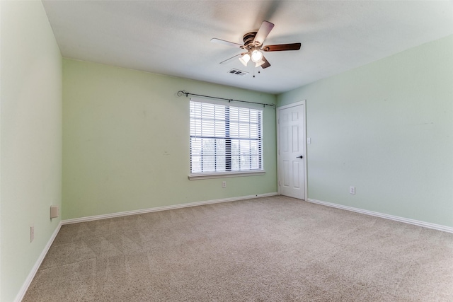 carpeted spare room featuring ceiling fan