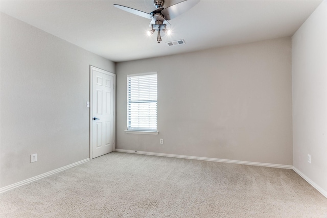 carpeted spare room featuring ceiling fan