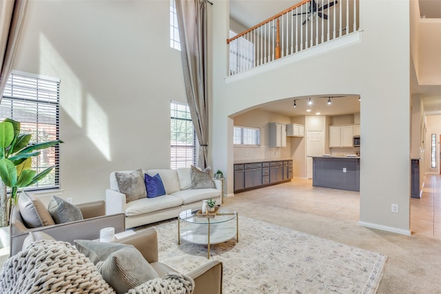 living room featuring light carpet and a towering ceiling