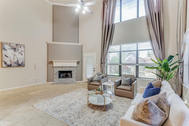 living room featuring ceiling fan, carpet flooring, and a high ceiling