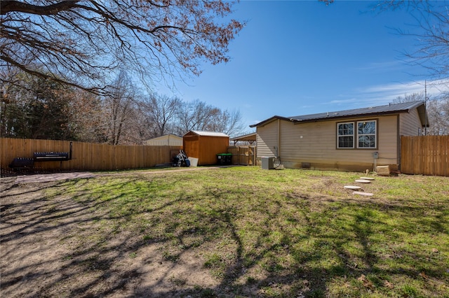 view of yard featuring central AC and a storage unit