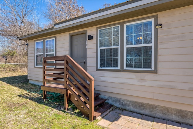 view of exterior entry featuring a yard