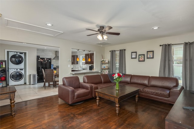 living room with ceiling fan, wood-type flooring, and stacked washing maching and dryer