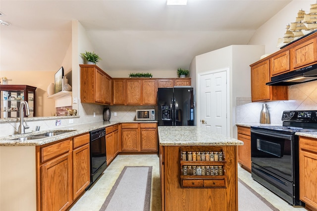 kitchen with lofted ceiling, sink, a center island, black appliances, and decorative backsplash