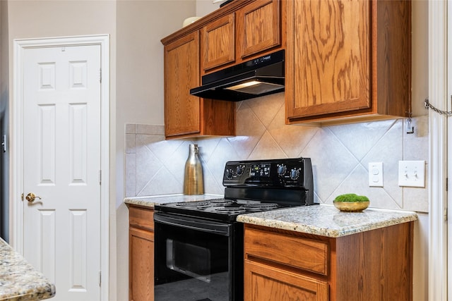 kitchen with light stone countertops, backsplash, and black / electric stove
