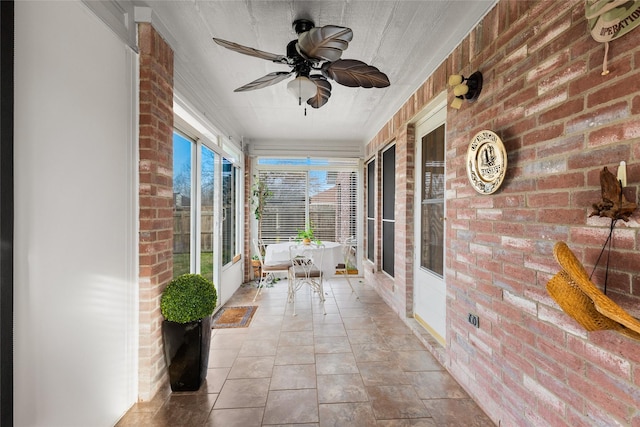 unfurnished sunroom featuring ceiling fan