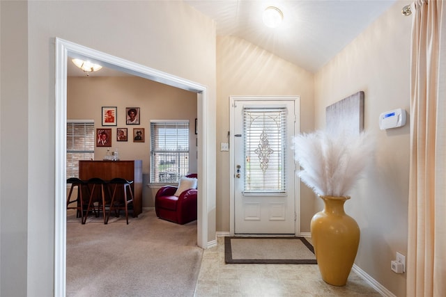 doorway to outside with lofted ceiling and light colored carpet