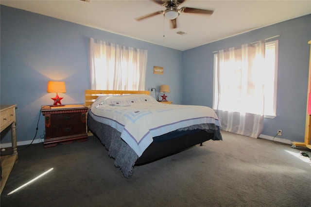 bedroom featuring a ceiling fan, visible vents, dark carpet, and baseboards