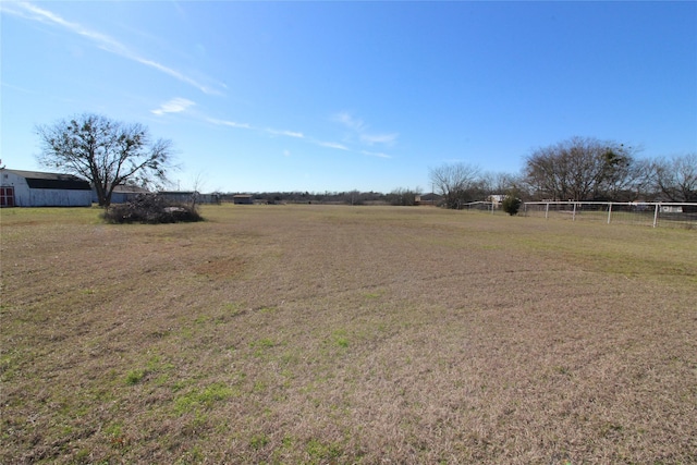 view of yard featuring a rural view and fence