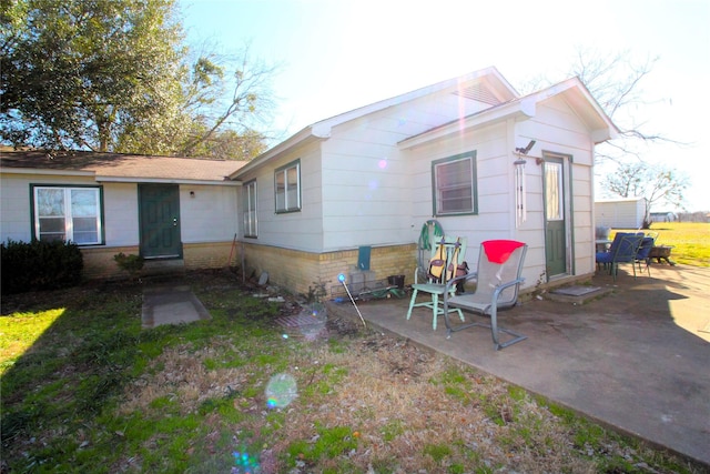 back of property featuring entry steps and a patio