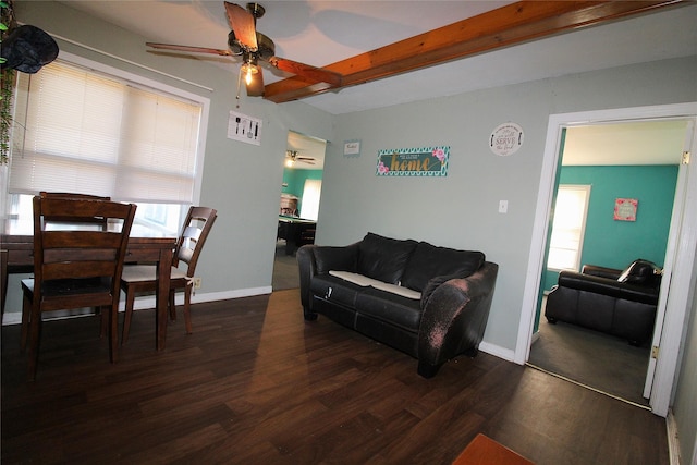 living room with dark wood-style floors, beam ceiling, baseboards, and a ceiling fan