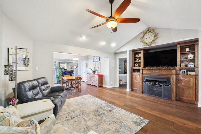 living area with a fireplace, vaulted ceiling, wood finished floors, and ceiling fan