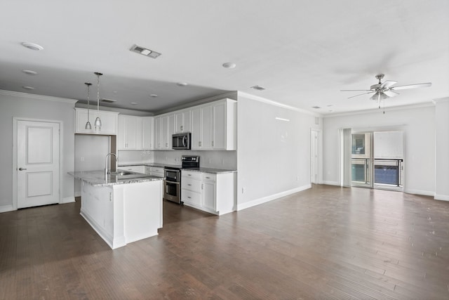 kitchen with appliances with stainless steel finishes, pendant lighting, light stone countertops, a kitchen island with sink, and white cabinets