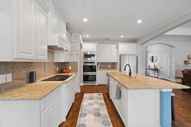 kitchen featuring stainless steel appliances, white cabinetry, a kitchen island with sink, and sink