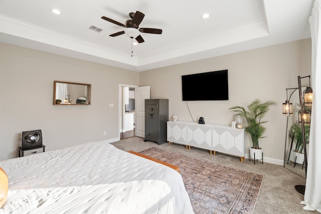 carpeted bedroom featuring crown molding, ceiling fan, and a tray ceiling