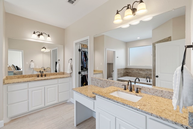 bathroom with vanity, a tub, and toilet