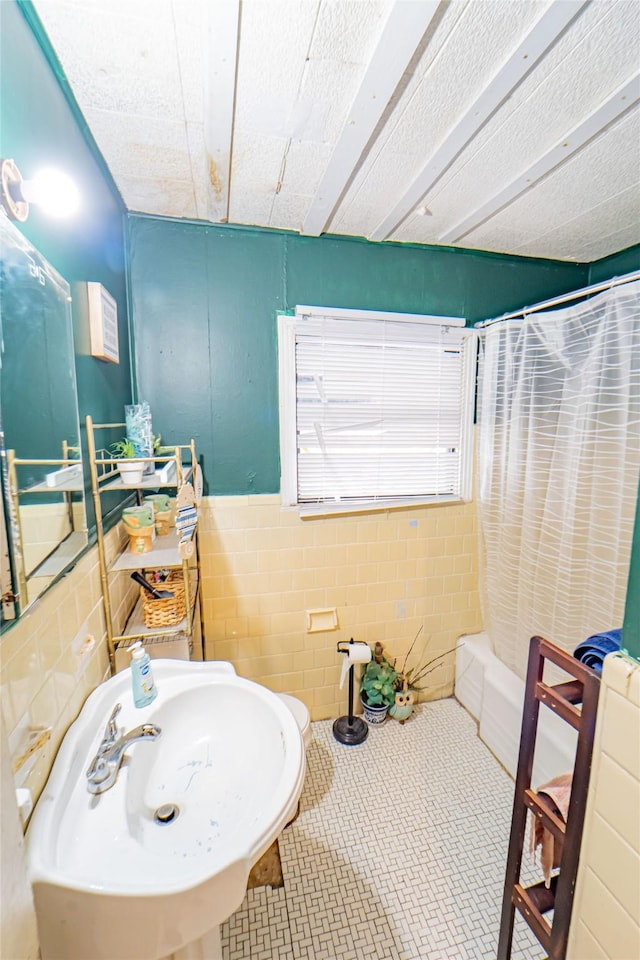 bathroom with tile walls, sink, tile patterned flooring, and shower / bath combo with shower curtain