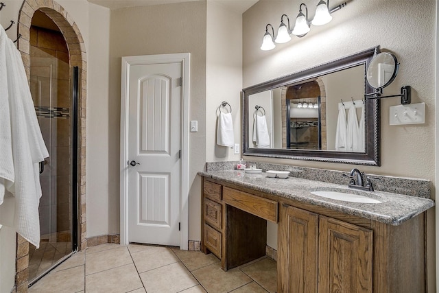 full bath featuring tile patterned flooring, vanity, and a stall shower