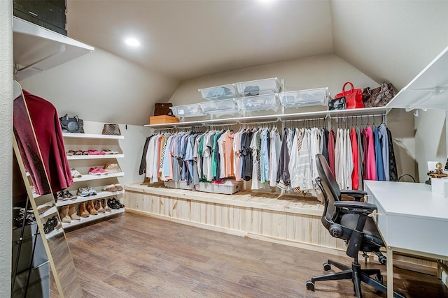 walk in closet with wood finished floors and vaulted ceiling