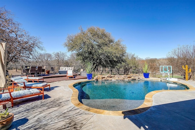 view of swimming pool featuring a deck, a patio area, fence, and a fenced in pool