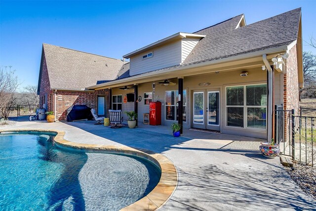 back of property with a fenced in pool, fence, french doors, a patio area, and a ceiling fan