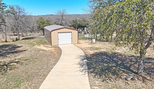 view of yard featuring a storage shed, an outbuilding, fence, and a detached garage