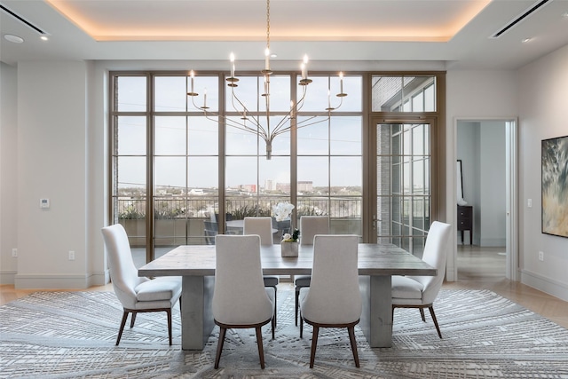 dining space with a tray ceiling, baseboards, and a healthy amount of sunlight