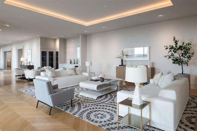 living area featuring a tray ceiling and recessed lighting