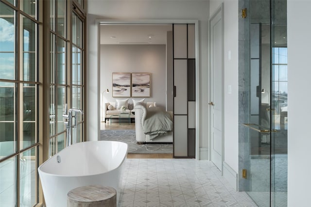 ensuite bathroom featuring ensuite bathroom and a soaking tub