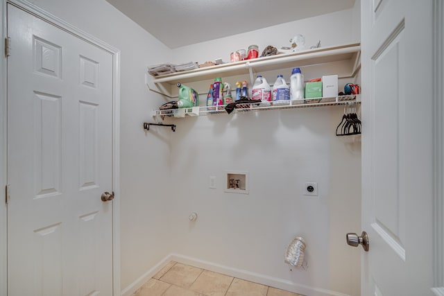 clothes washing area with washer hookup, light tile patterned floors, electric dryer hookup, laundry area, and baseboards