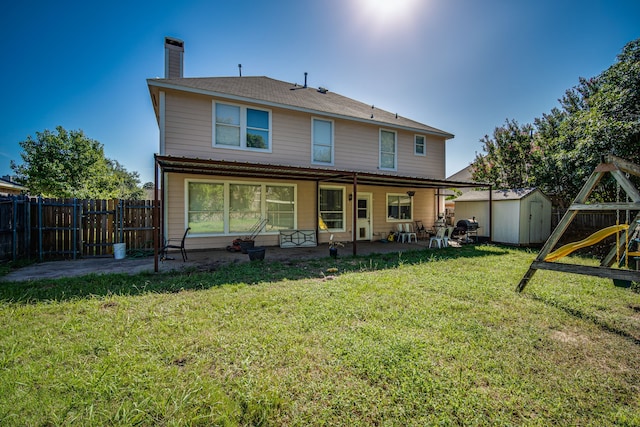 back of house with a lawn, a fenced backyard, an outbuilding, a patio area, and a shed