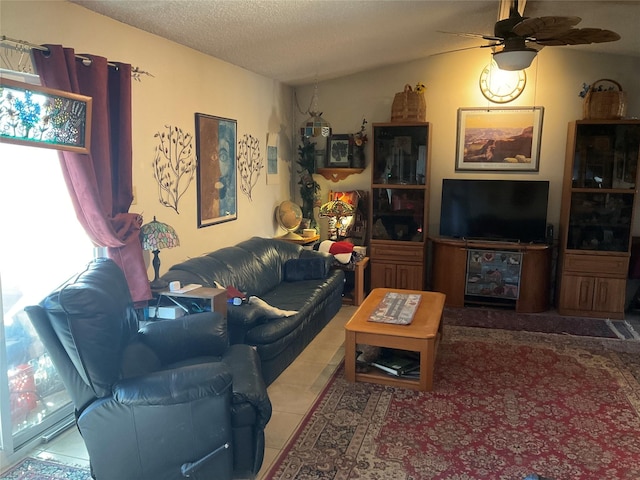 living room featuring ceiling fan, vaulted ceiling, and a textured ceiling