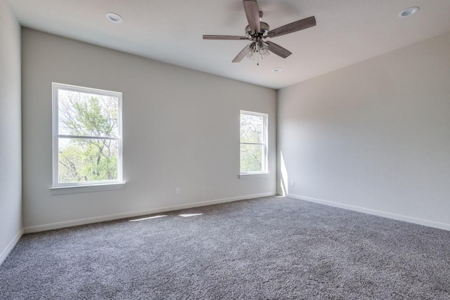 carpeted spare room with ceiling fan and a wealth of natural light