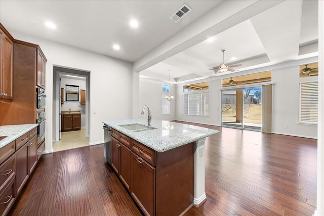 kitchen with dark wood-type flooring, visible vents, stainless steel appliances, and a sink