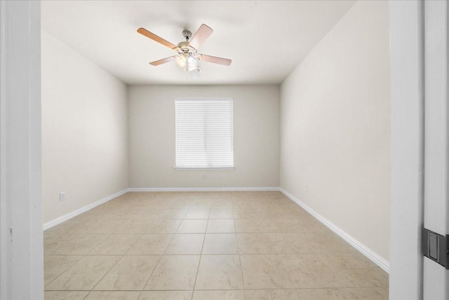 empty room featuring light tile patterned floors, ceiling fan, and baseboards