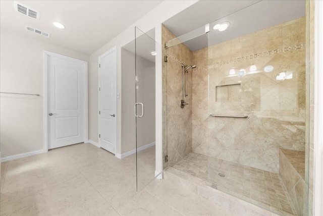 bathroom featuring tile patterned flooring, a shower stall, visible vents, and baseboards