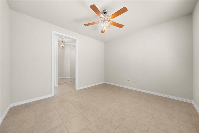 unfurnished room featuring a ceiling fan and baseboards