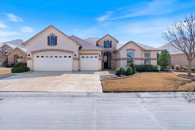 view of front of house with driveway, an attached garage, and stucco siding