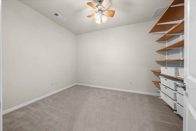 carpeted empty room with ceiling fan, visible vents, and baseboards