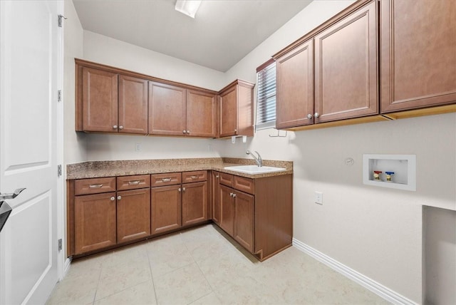 laundry room featuring cabinet space, light tile patterned floors, baseboards, washer hookup, and a sink