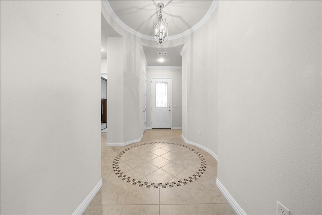 foyer with visible vents, baseboards, ornamental molding, a notable chandelier, and light tile patterned flooring