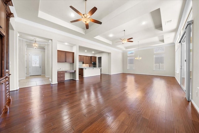 unfurnished living room with baseboards, visible vents, a raised ceiling, and dark wood finished floors