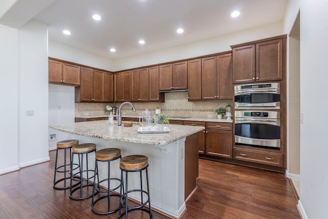 9525 Crestview Dr, Denton, TX 76207 - kitchen with a sink, decorative backsplash, dark wood-style flooring, a kitchen island with sink, and recessed lighting